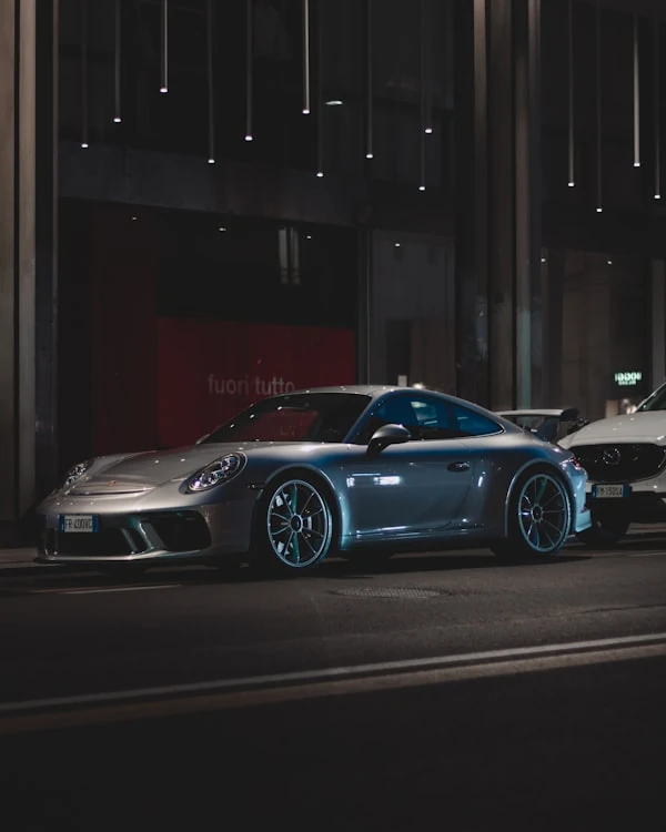 Silver Porsche 911 GT3 Touring on a city street at night