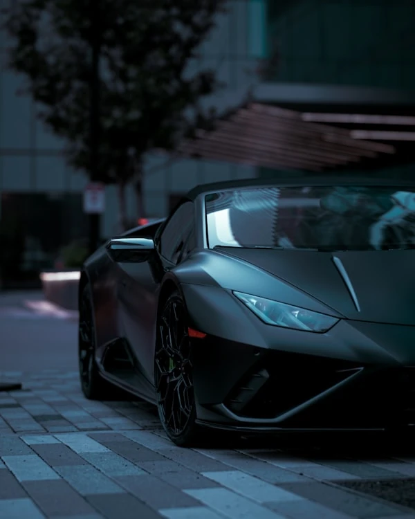 Matte grey Lamborghini Huracán EVO Spyder on a city street at dusk